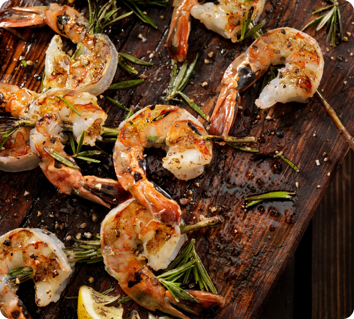 Grilled shrimp with herbs on wooden board